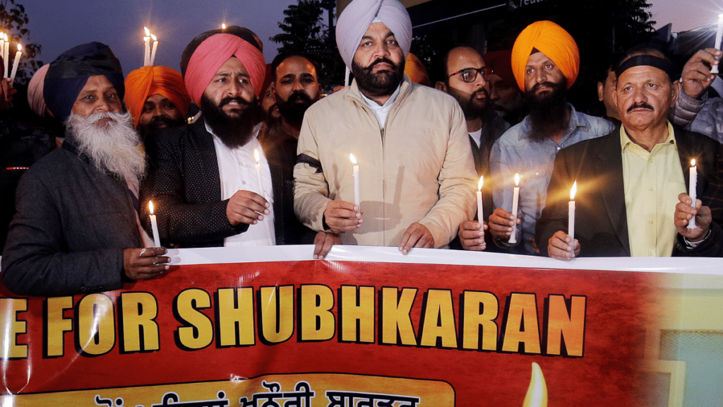 Congress MP Gurjeet Singh Aujla (3-R-in violet turban) along with members of various NGOs and social workers take part in a candlelight vigil for Shubhkaran Singh, a farmer who died at Khanauri border during the ongoing farmers